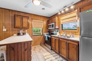 a kitchen with wooden cabinets and a stainless steel refrigerator at Sunny Daze KDH by Village Reality in Kill Devil Hills +26 photos