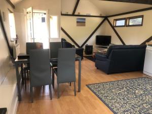 a living room with a table and chairs and a couch at Sycamores Barn - Detached, Private, Secluded Country Retreat in Brighstone