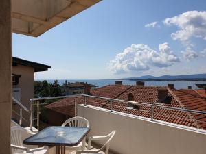 a table and chairs on a balcony with a view of the water at Стаи за гости Мистрал in Primorsko