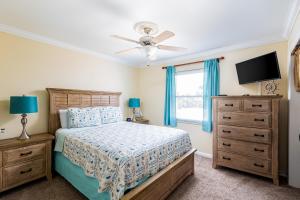 um quarto com uma cama e uma televisão de ecrã plano em Coastal Haven em Pensacola Beach