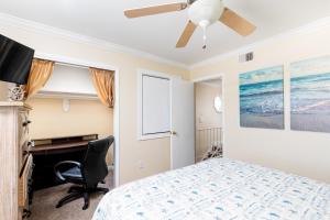a bedroom with a bed and a desk and a ceiling fan at Coastal Haven in Pensacola Beach