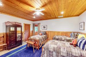1 dormitorio con 2 camas y techo de madera en Water's Edge Cabin, en Sylva