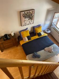 a bedroom with two beds with yellow and blue pillows at Chambres d’hôtes plateau des mille étangs 