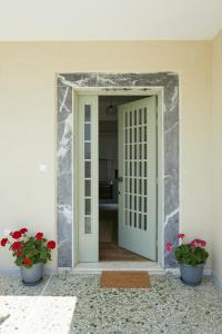 an open door with two pots of flowers in a room at Mosaic Luxury House in Chios