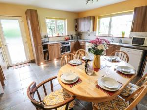 a kitchen with a wooden dining table and chairs at Ballaghboy Cottage in Boyle