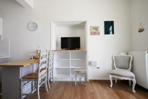 a room with a desk and a tv and chairs at Mosaic Luxury House in Chios