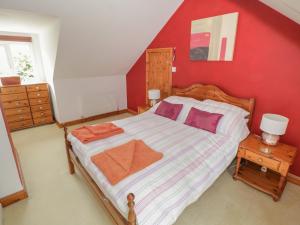 a bedroom with a large bed with a red wall at Ballaghboy Cottage in Boyle