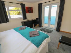 a bedroom with a bed with a view of the ocean at Ty Mawr in Haverfordwest