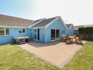 a blue house with a patio with a table and a grill at Ty Mawr in Haverfordwest