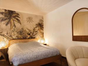 1 dormitorio con cama, espejo y silla en L'oasis du château ! "climatisé" en Gréoux-les-Bains