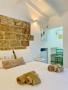 una camera con un letto bianco e un muro di mattoni di Nonna Veronica a Gemini