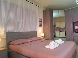 a bedroom with a large bed with towels on it at Alice's House - Monolocale in Pula