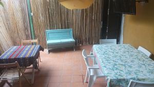 ナポリにあるIl giardino nascostoのテーブル、椅子、テレビが備わる客室です。