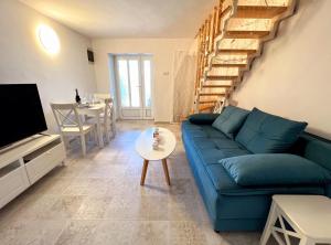 a living room with a blue couch and a table at Little home in Rab