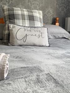 Una cama con una almohada que dice ser nuestro invitado en Bella Vista, en Paignton