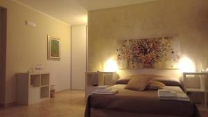 ein Schlafzimmer mit einem Bett und einem Wandgemälde in der Unterkunft Raggi di Sole in Custonaci