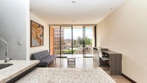 a kitchen and living room with a couch and a table at Hotel & Suites en Cuenca, Venue Batán in Cuenca
