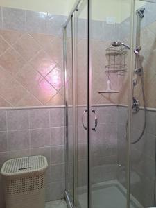 a bathroom with a shower with a glass door at Alice's House - Monolocale in Pula +9 photos
