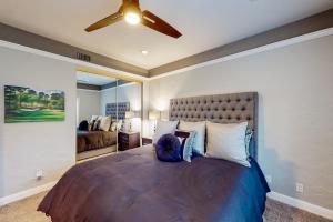 - une chambre avec un grand lit et un ventilateur de plafond dans l'établissement Palm Retreat, à La Quinta