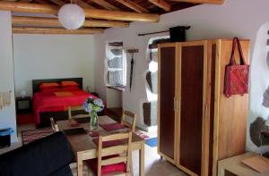 a living room with a bed and a table in a room at Palheiro da Assomada in Faja Grande
