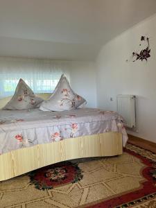 a bedroom with a bed with pillows on it at Casa Ilinca in Filioara
