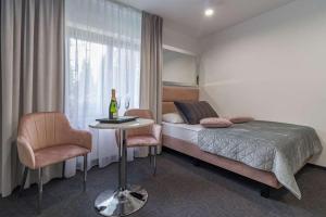 1 dormitorio con 1 cama, 1 mesa y 1 silla en Villa Viola, en Mielno
