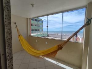 a hammock in a room with a view of the beach at Amazônia Praia Hotel in Tibau