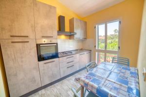 a kitchen with a table and a kitchen with a window at Casa Vacanza Sole & Luna in Stintino