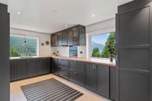 a kitchen with black cabinets and a large window at 极光民宿Northern Lights in Laksvatn
