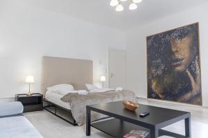 ein Schlafzimmer mit einem Bett, einem Tisch und einem Gemälde in der Unterkunft Stunning Apartment - Ideal for 3 people in Wien