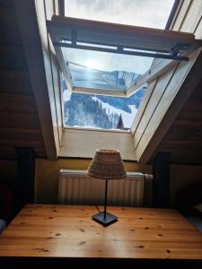 a table in a room with a large window at Apartments Belopeški Dvori in Kranjska Gora