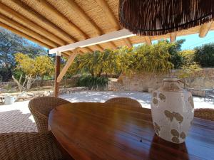 um vaso sentado numa mesa de madeira sob um telhado em B&B Vila Alegria CH1 ESTOI em Estói