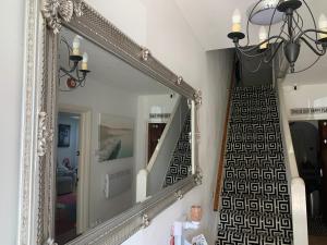 a mirror with a staircase in a living room with a stair case at Bella Vista in Paignton