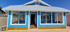 uma pequena casa azul com muitas janelas em Hostel Litoral em Peruíbe