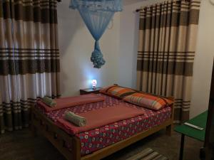 1 dormitorio con 1 cama con sábanas y cortinas rojas en Yala Avian Eye Safari, en Buttala