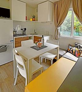 uma cozinha e sala de estar com mesa e cadeiras em Mylooking vacanze Porlezza em Porlezza