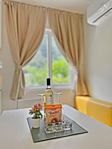 una bottiglia di vino su un tavolo accanto a una finestra di Mylooking vacanze Porlezza a Porlezza