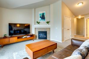 a living room with a couch and a fireplace at Alaska Retreat with Balcony, Near Earthquake Park! in Anchorage