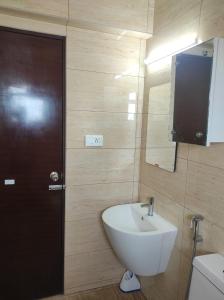 a bathroom with a white sink and a mirror at Olive Celestina in Kottayam
