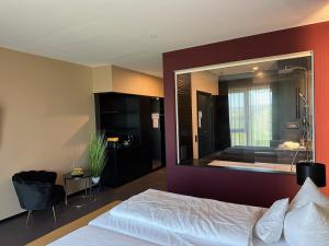 Primetime Hotel في أوليمبياذا: غرفة نوم بسرير ومرآة كبيرة