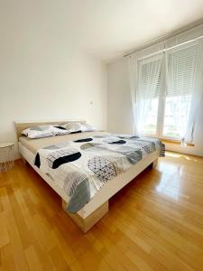 ein großes Bett in einem Schlafzimmer mit Holzboden in der Unterkunft Little Sunlight Oasis in Split