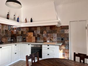 a kitchen with white cabinets and a wooden table at Casa Bizarra in Castanheira de Pêra