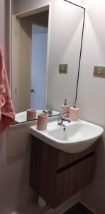y baño con lavabo blanco y espejo. en Apartamento Villarrica, en Villarrica