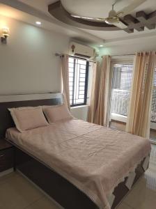 a large bed in a room with two windows at Olive Celestina in Kottayam