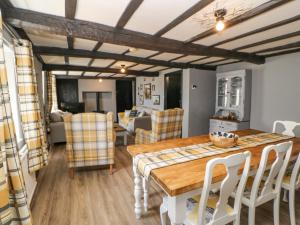 uma cozinha e sala de jantar com uma mesa de madeira e cadeiras em Rock Cottage em Penrith