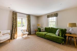 a living room with a green couch and a chair at Mermaid Cottage in Port Isaac