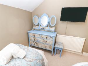 a bedroom with a dresser with two mirrors on it at Rock Cottage in Penrith