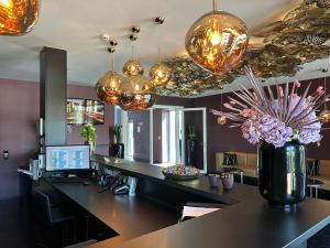 an office with a desk with a computer and chandeliers at Primetime Hotel in Gießen