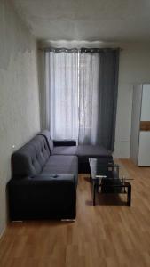 a living room with a black couch and a glass table at Premier Double room MZ in Vienna