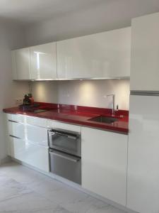a kitchen with white cabinets and a red counter top at Escale à Saint-Tropez in Saint-Tropez